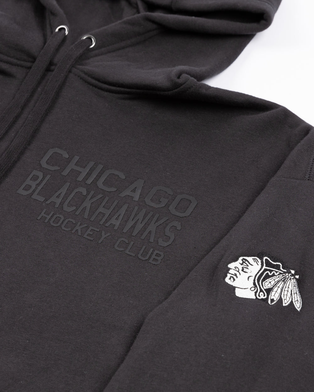 black CCM hoodie with tonal Chicago Blackhawks Hockey Club wordmark graphic on left chest and black and white primary logo embroidered on left shoulder - front detail lay flat