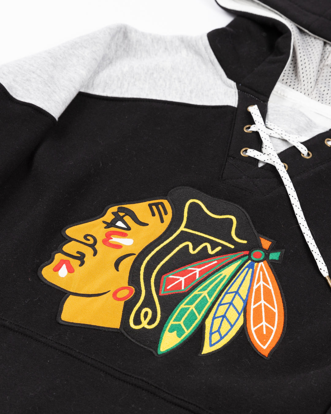 black, red, grey and white CCM jersey-inspired hoodie with Chicago Blackhawks primary logo on front - front detail lay flat