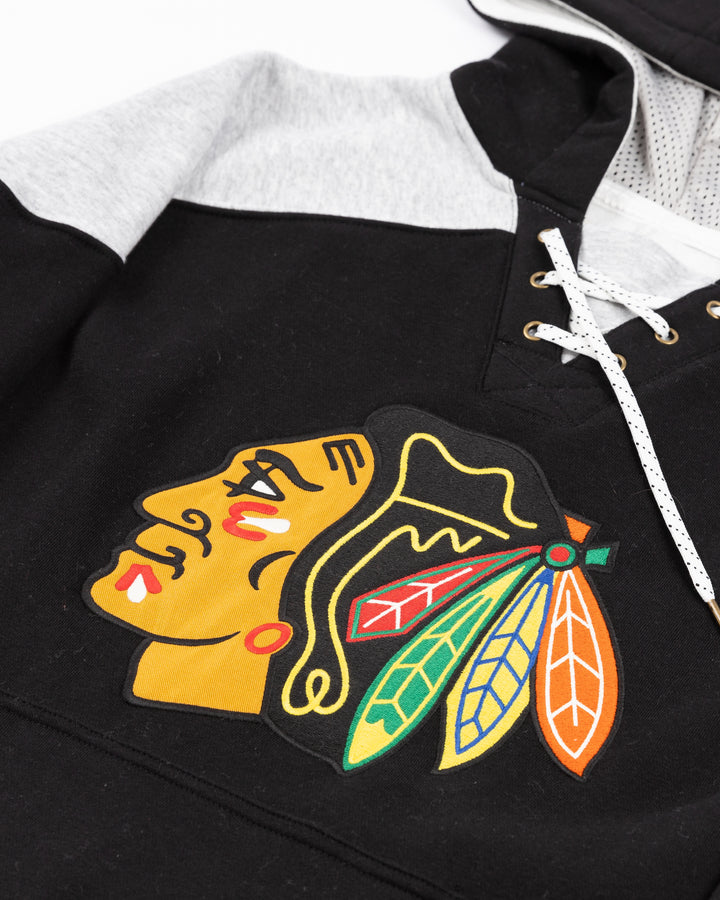 black, red, grey and white CCM jersey-inspired hoodie with Chicago Blackhawks primary logo on front - front detail lay flat