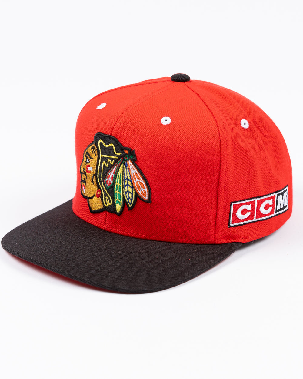 two tone red and black CCM flat brim hat with Chicago Blackhawks primary logo embroidered on front and CCM logo on left side - left angle lay flat