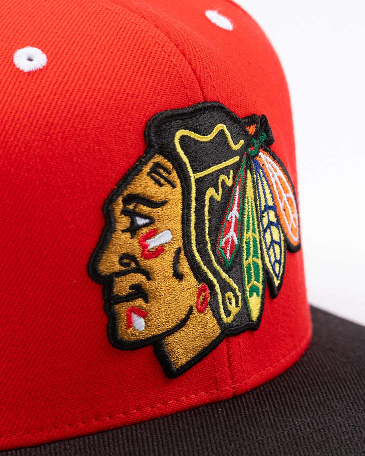 two tone red and black CCM flat brim hat with Chicago Blackhawks primary logo embroidered on front and CCM logo on left side - front detail lay flat