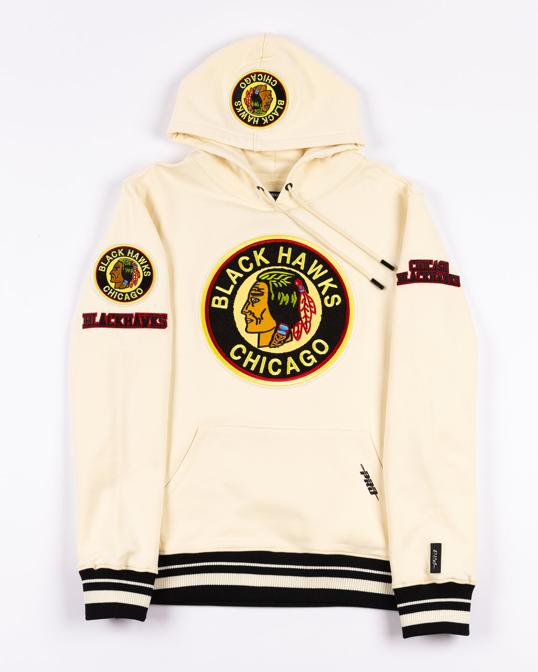 cream Pro Standard hoodie with black striping on hem and cuffs and vintage Chicago Blackhawks logo patches on front, hood and shoulders - front lay flat