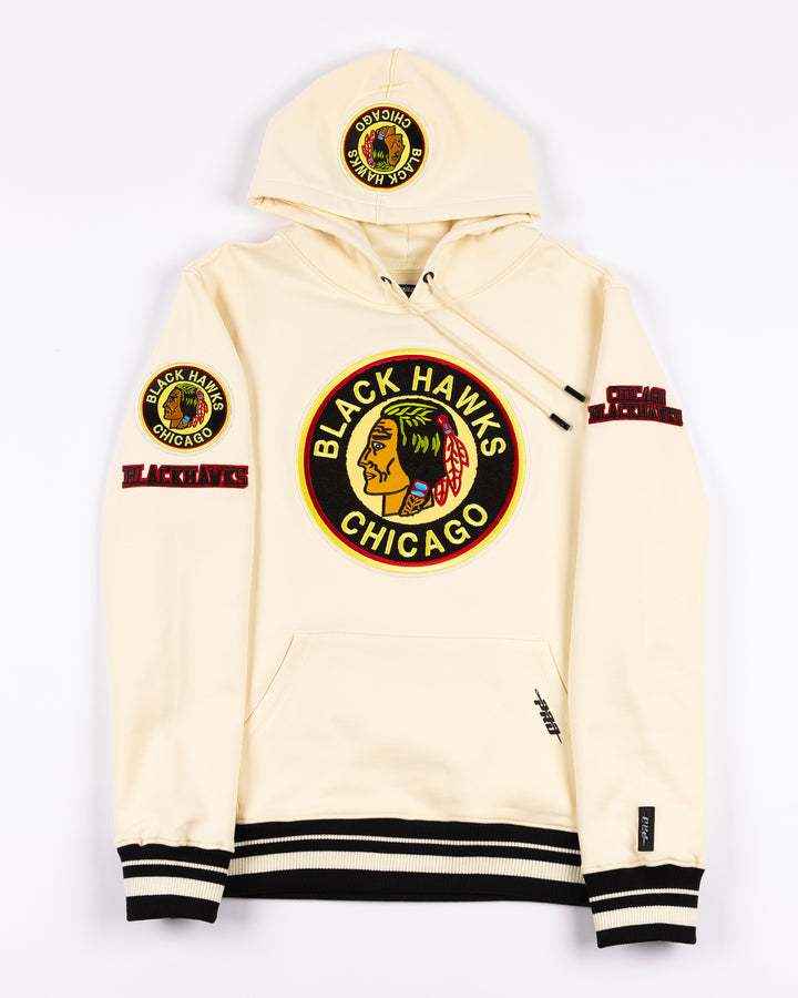 cream Pro Standard hoodie with black striping on hem and cuffs and vintage Chicago Blackhawks logo patches on front, hood and shoulders - front lay flat