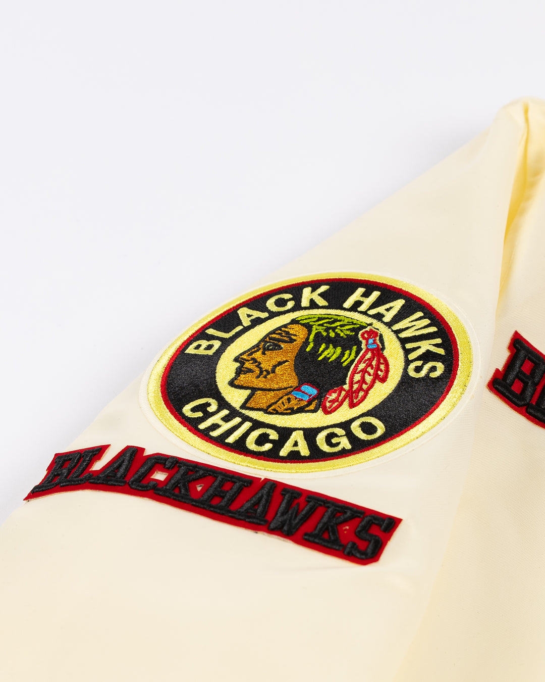 cream satin Pro Standard varsity jacket with vintage Chicago Blackhawks patches on shoulders, chest and back - shoulder detail lay flat