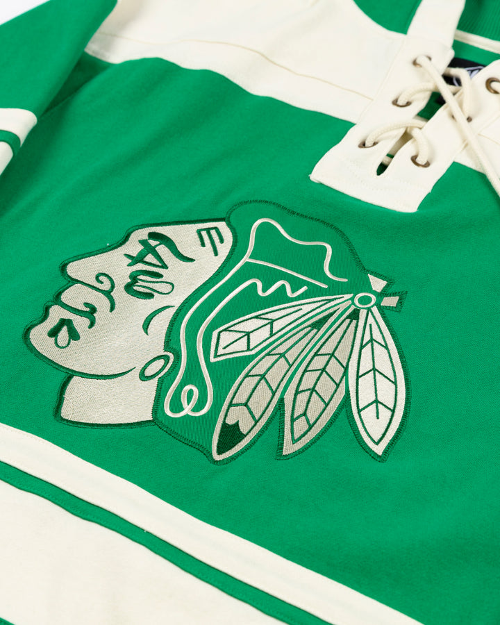 '47 brand green and white hockey inspired lace up hoodie with shamrocks on shoulders and Chicago Blackhawks primary logo on front and Connor Bedard name and number on back - front detail lay flat