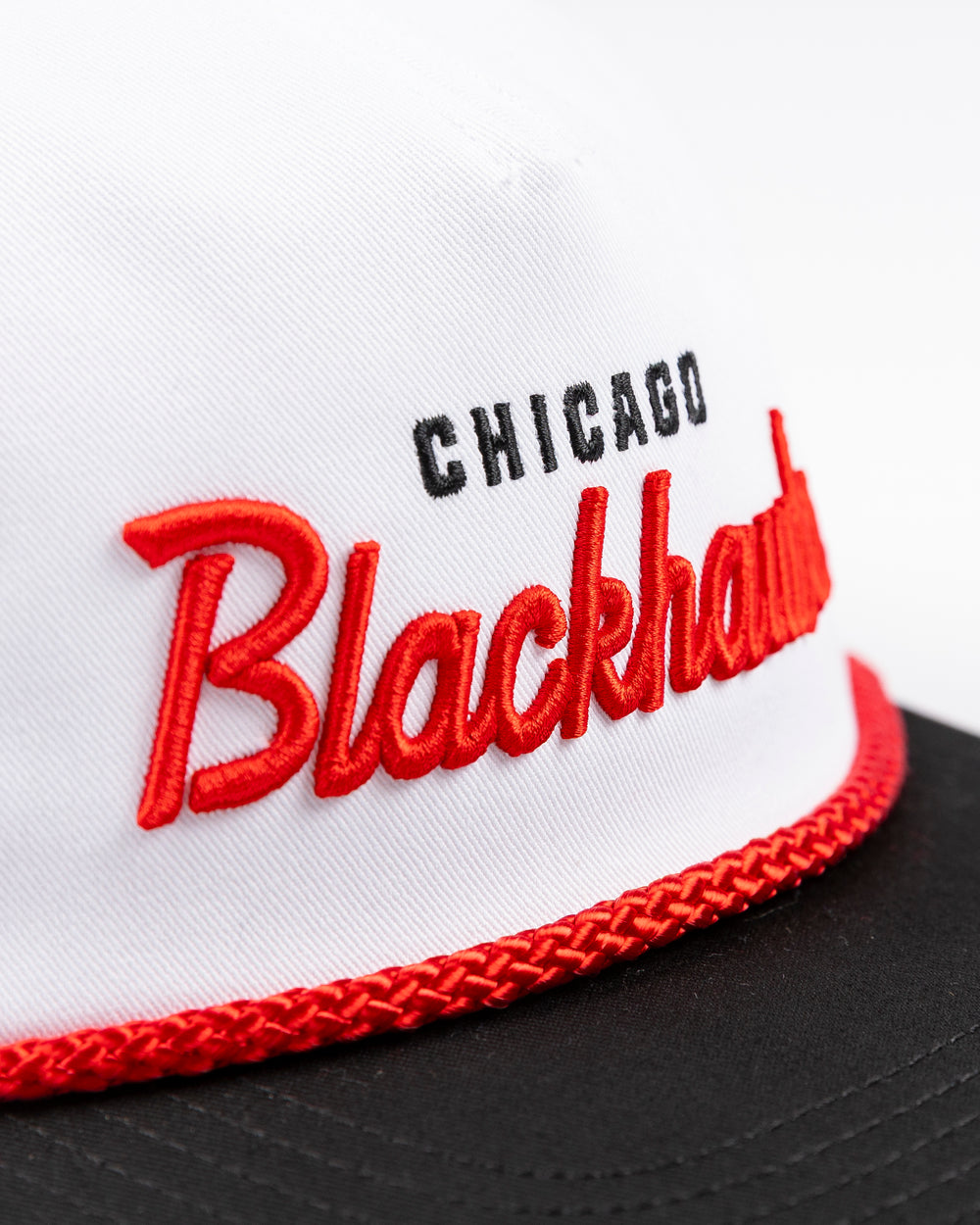 American Needle white rope snapback hat with Chicago Blackhawks wordmark on the front and primary logo on left side - front detail lay flat