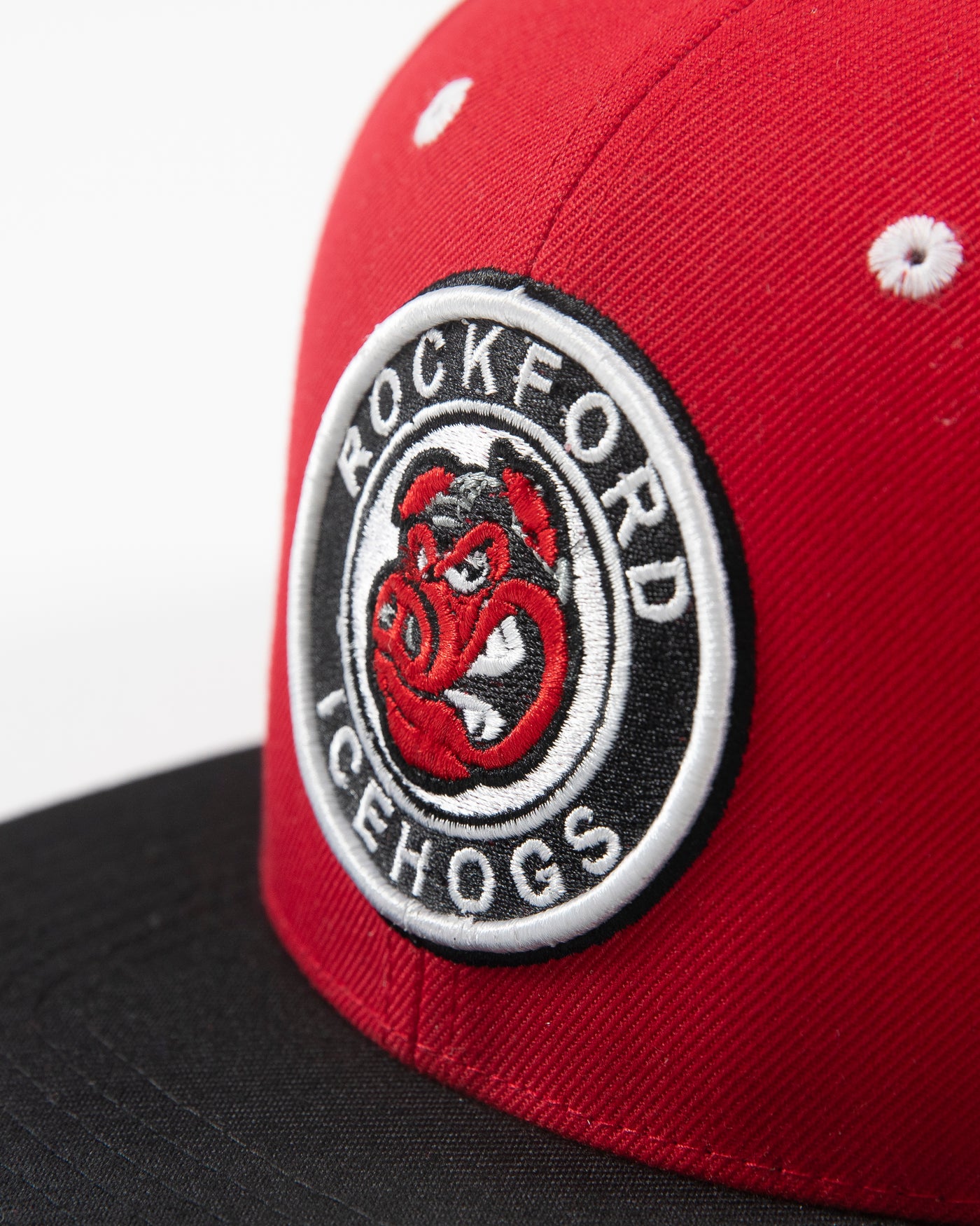 Black and red flat brim adjustable cap with Rockford IceHogs classic logo embroidered on front - detail lay flat