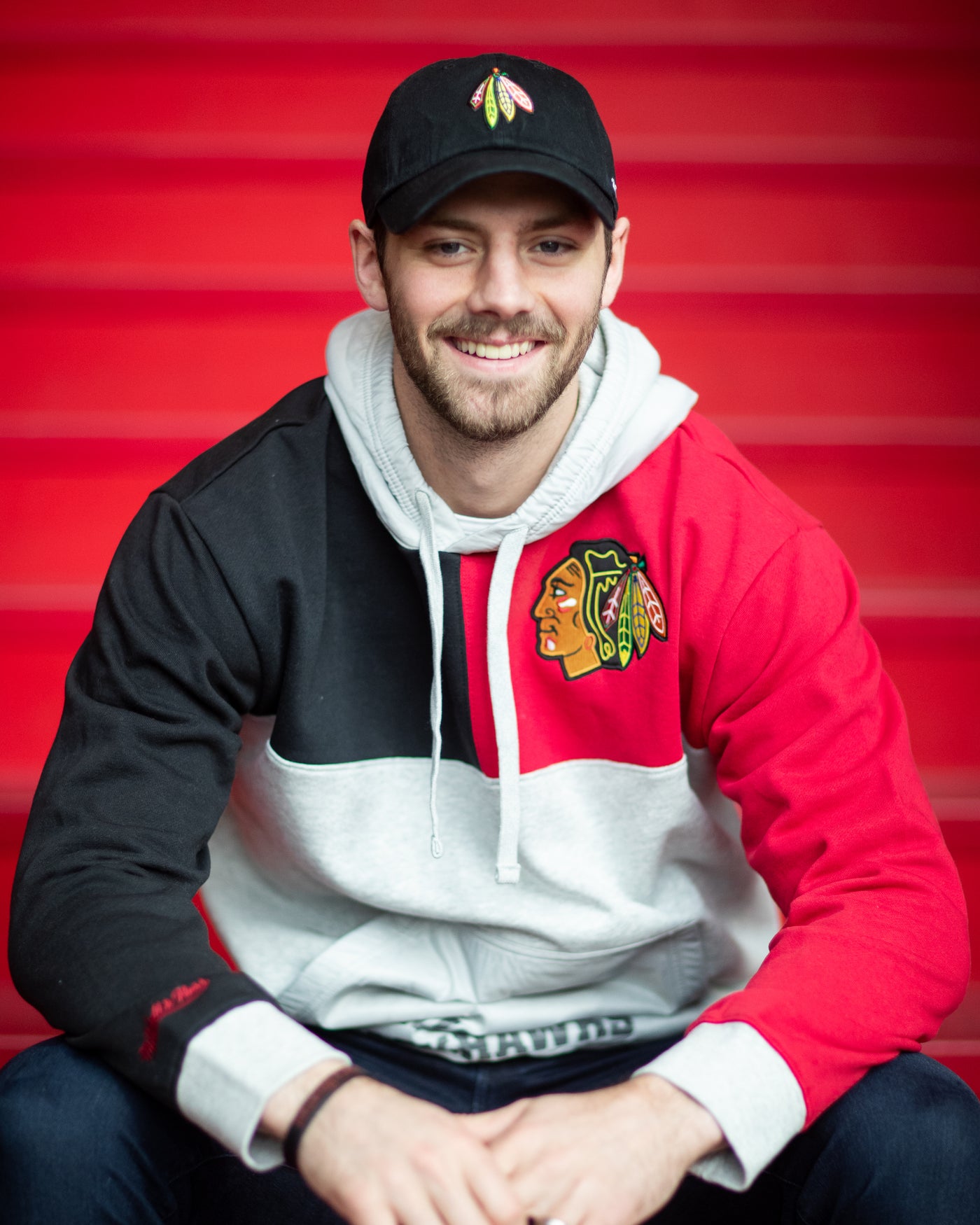 Jason Dickinson in the Mitchell & Ness colorblock tie breaker hoodie with Chicago Blackhawks Primary logo on left chest
