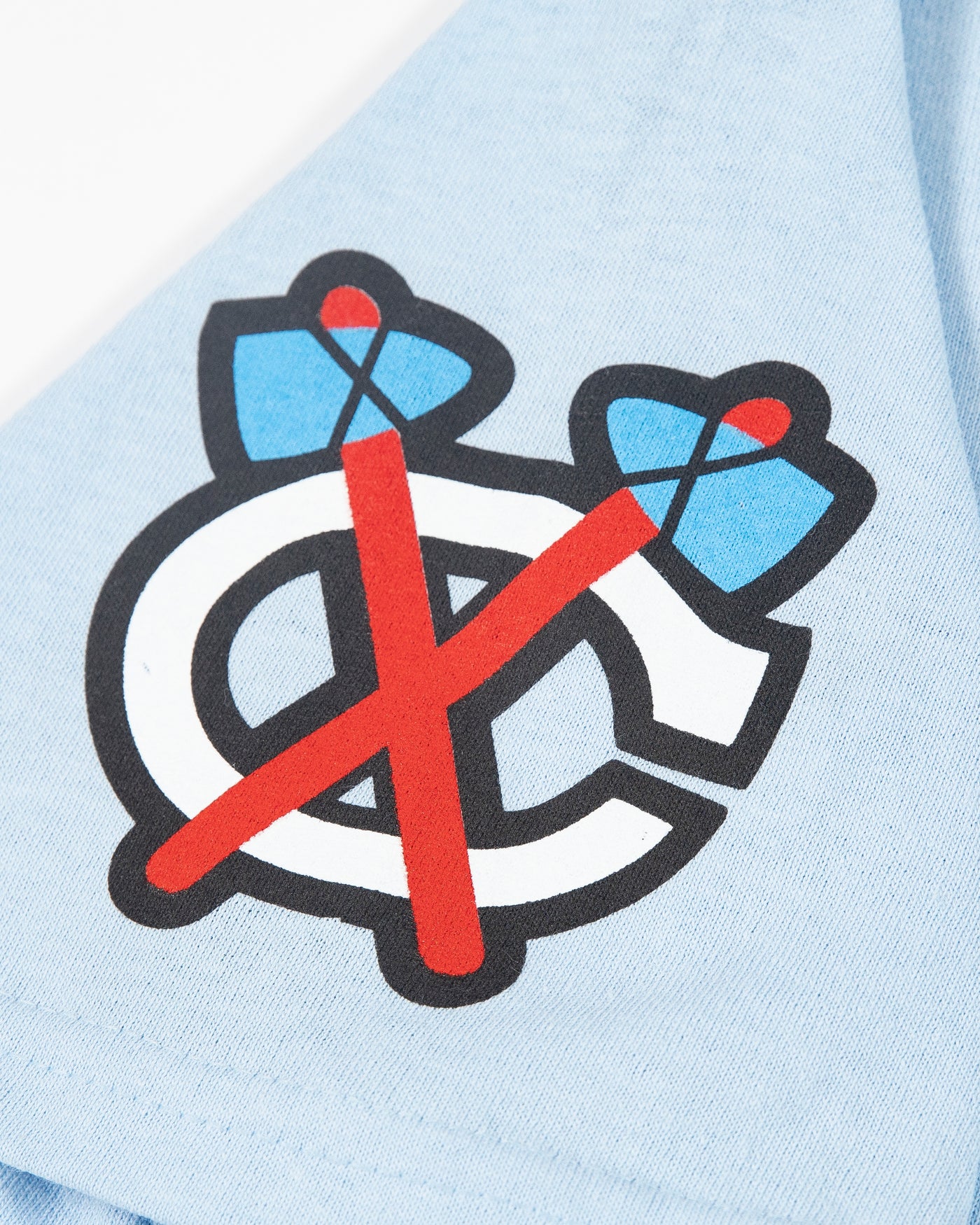 light blue tee with tonal Chicago Blackhawks primary logo across chest, tonal secondary logo on right shoulder and star graphic on left shoulder - secondary logo detail image
