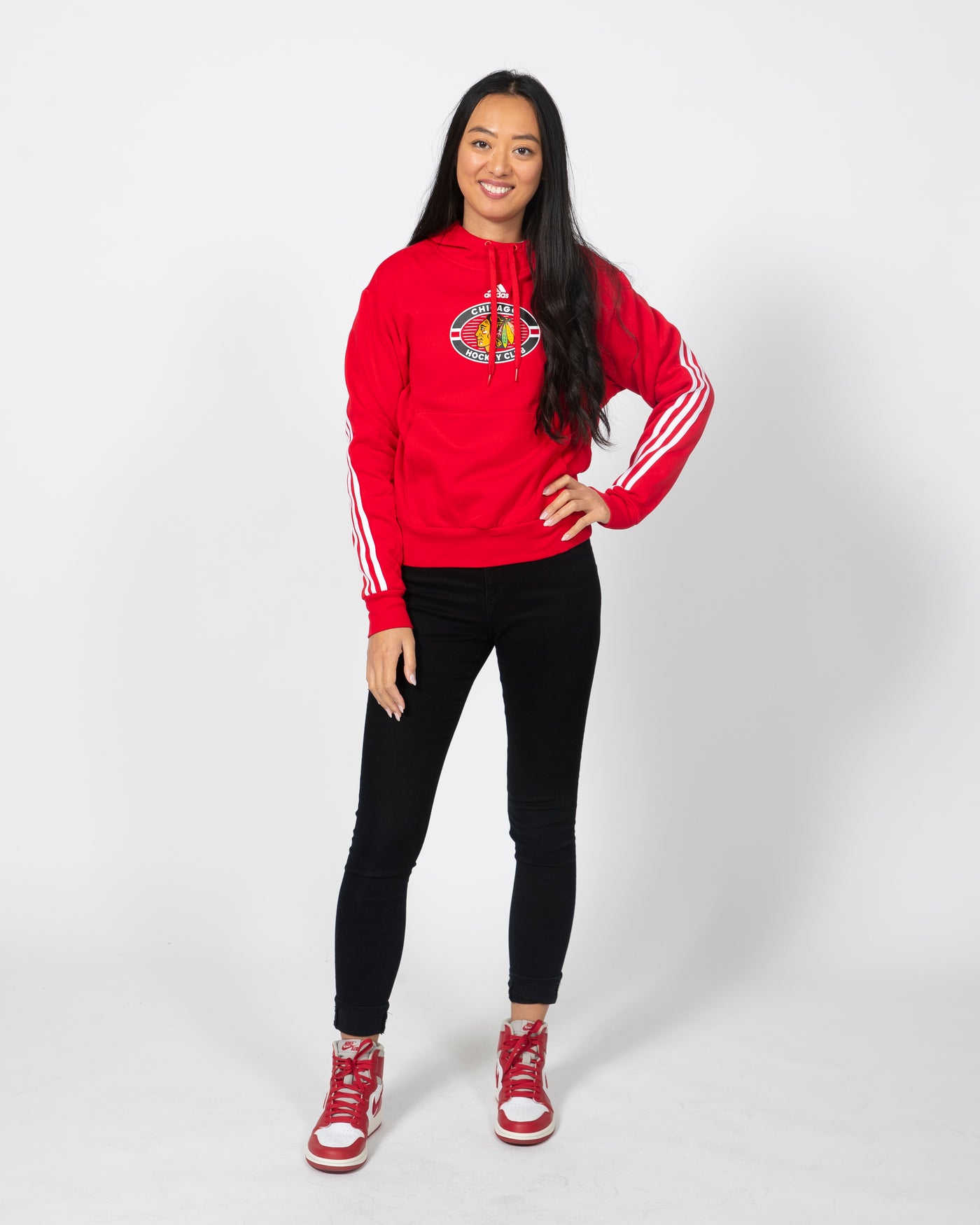 Red adidas hoodie with primary logo on center chest and three white stripes going down both arms - alt front view on model