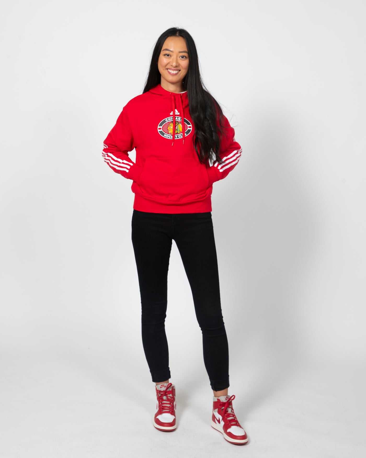 Red adidas hoodie with primary logo on center chest and three white stripes going down both arms - alt front view on model