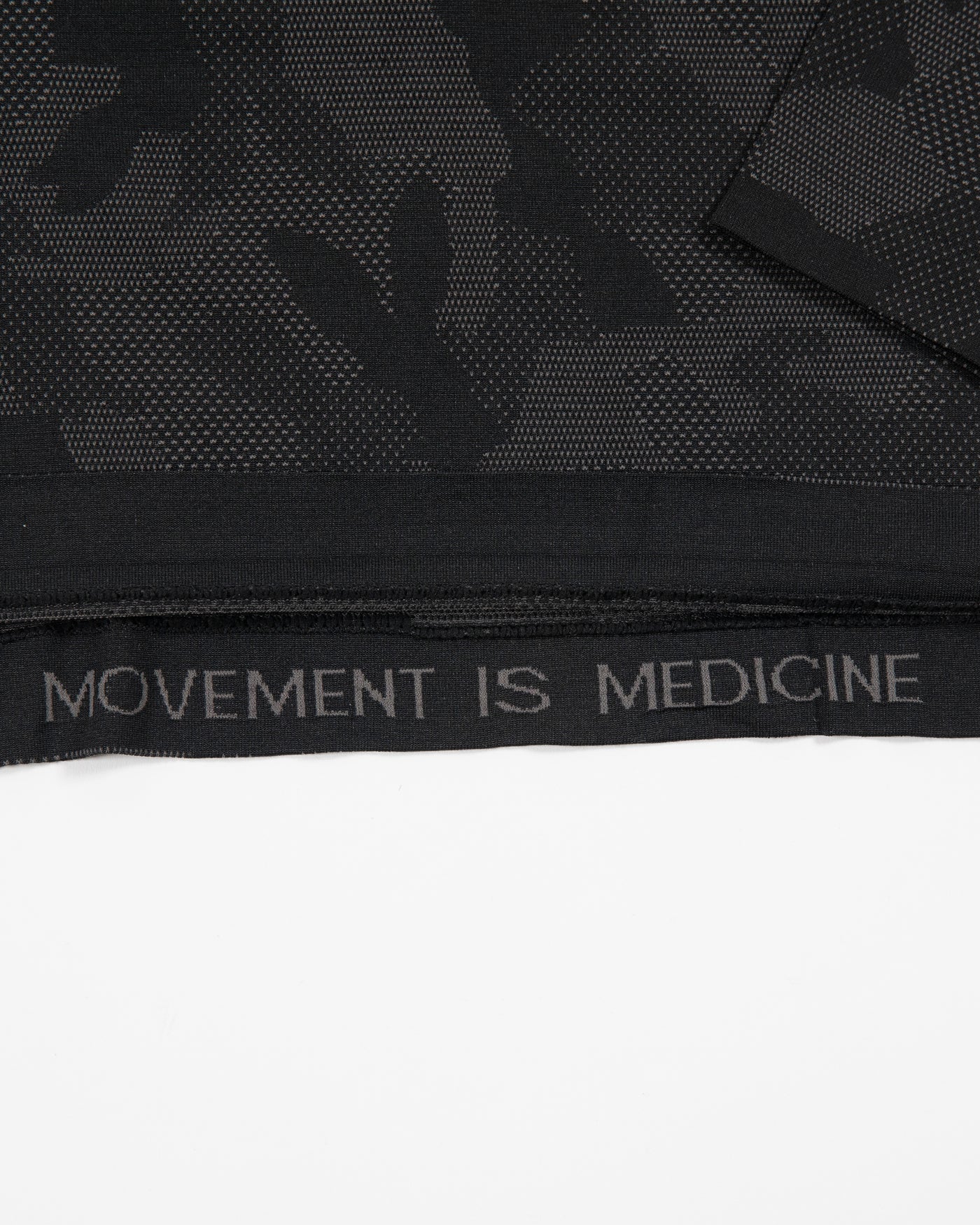 black camo lululemon long sleeve tee with primary logo on left shoulder - detail shot of Movement is Medicine graphic on inner lining