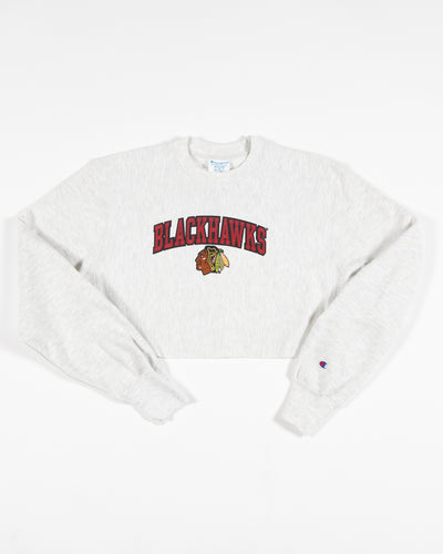 Heather grey Champion cropped crewneck with Chicago Blackhawks wordmark and primary logo embroidered across chest - front lay flat