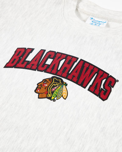 Heather grey Champion cropped crewneck with Chicago Blackhawks wordmark and primary logo embroidered across chest - detail lay flat