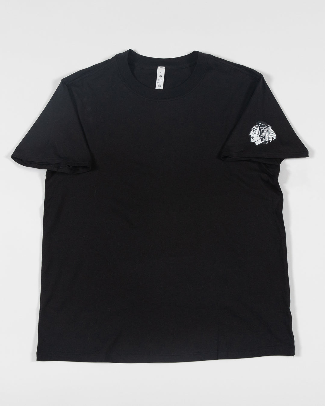 black lululemon short sleeve tee with Chicago Blackhawks tonal primary logo on left shoulder - front lay flat