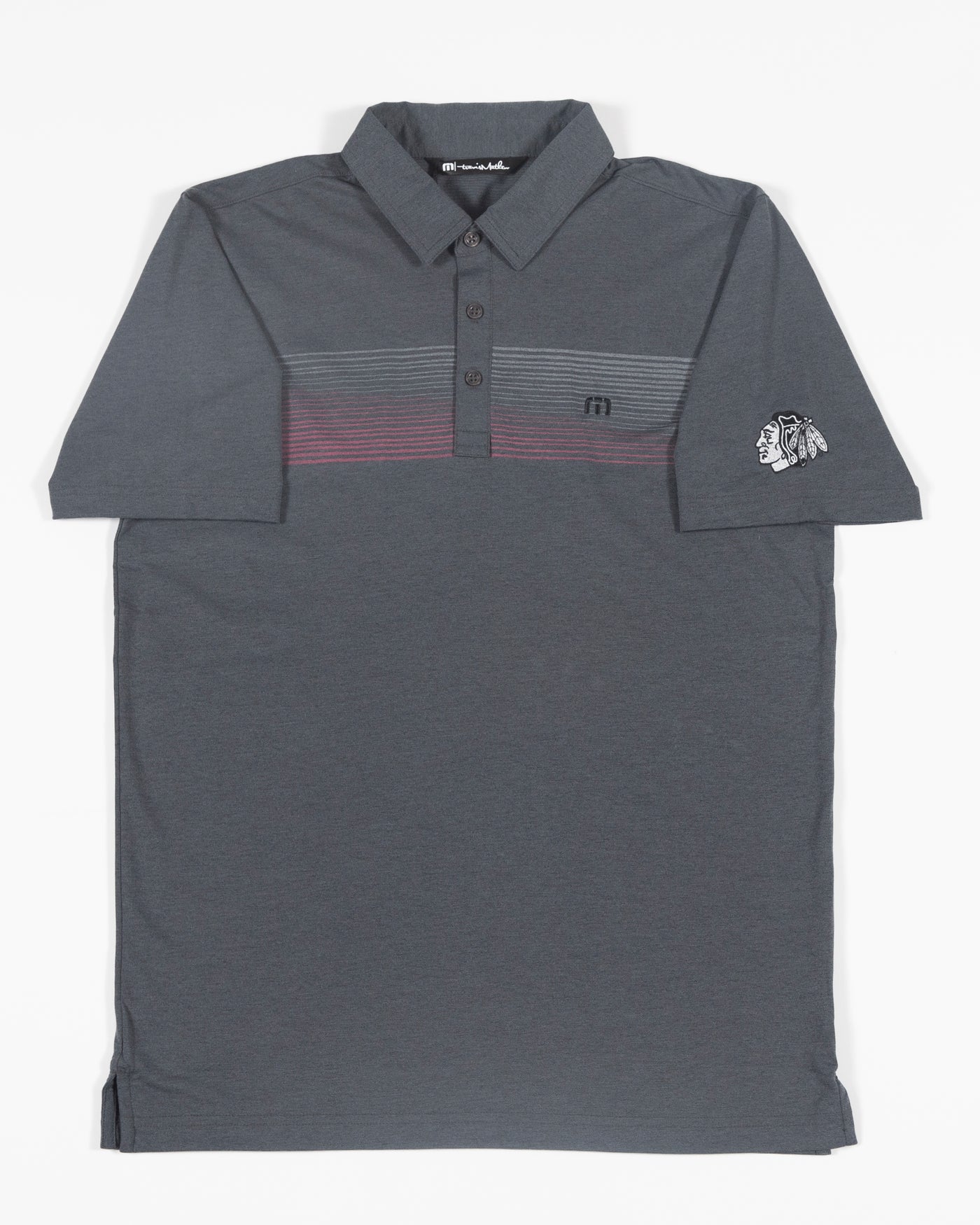 black TravisMathew polo with embroidered tonal primary logo on left shoulder - front lay flat