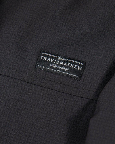 black TravisMathew zip up hoodie with embroidered Chicago Blackhawks primary logo on left shoulder - alt detail lay flat