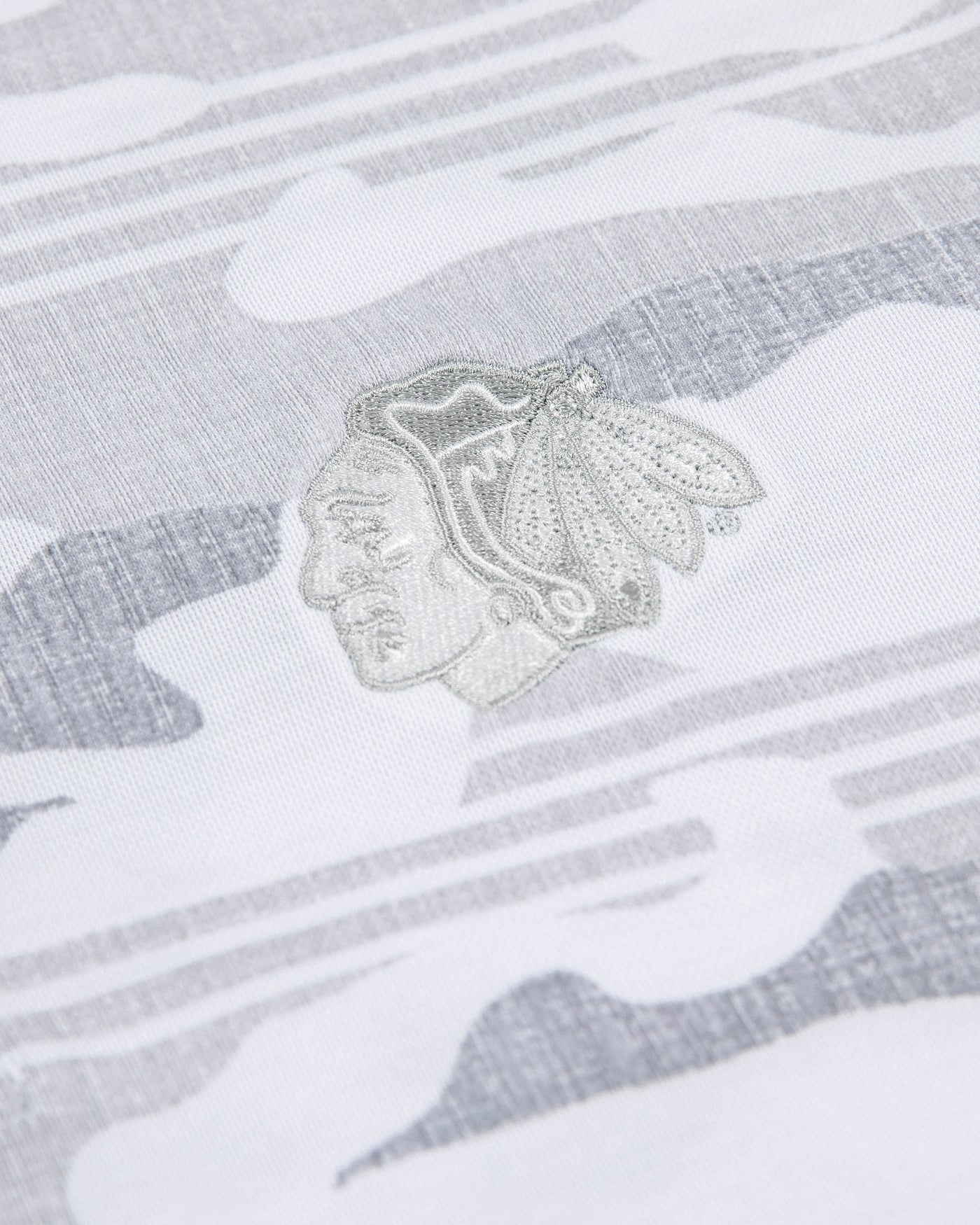 white camo TravisMathew polo with Chicago Blackhawks primary logo embroidered on left chest - detail lay flat