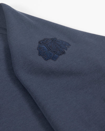 navy TravisMathew quarter zip with Chicago Blackhawks primary logo embroidered on left shoulder - detail lay flat